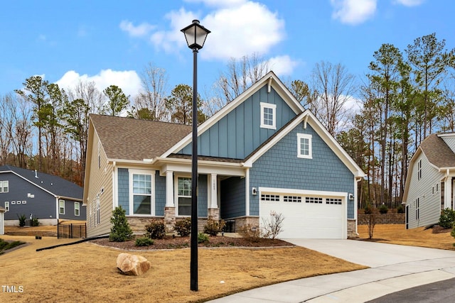 craftsman-style house with a garage, driveway, board and batten siding, and fence