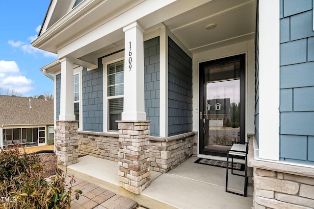 property entrance with covered porch and stone siding