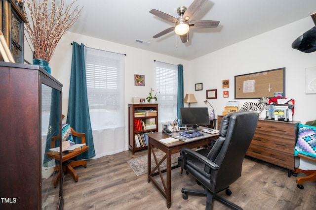 office area with ceiling fan, visible vents, and wood finished floors