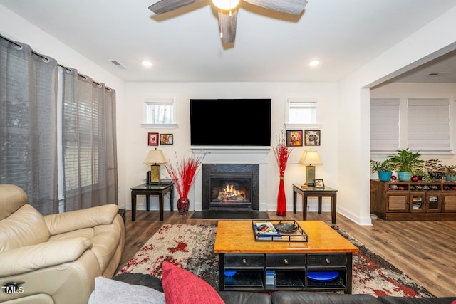 living area with a fireplace with flush hearth, recessed lighting, a ceiling fan, and wood finished floors