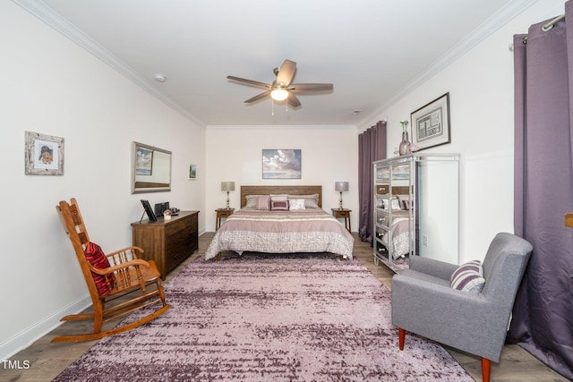 bedroom featuring ornamental molding, a ceiling fan, baseboards, and wood finished floors