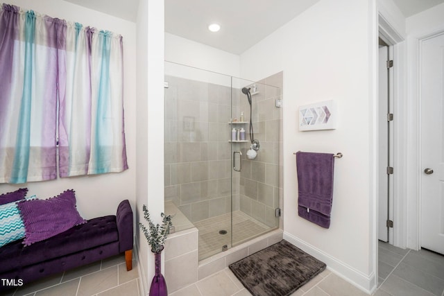 full bathroom featuring a stall shower, tile patterned flooring, and baseboards