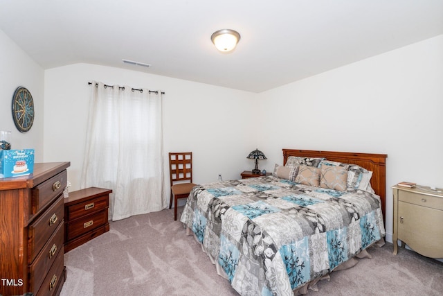 bedroom featuring light carpet, vaulted ceiling, and visible vents