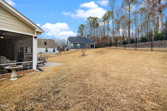 view of yard with a patio, a fenced backyard, and a sunroom