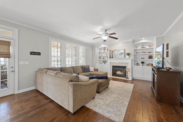 living room featuring dark wood-style floors, a wealth of natural light, and crown molding