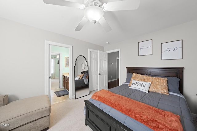 bedroom featuring a ceiling fan, connected bathroom, and light colored carpet