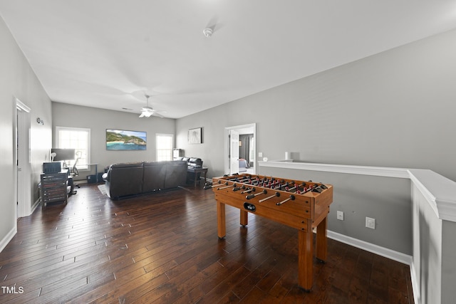 recreation room featuring dark wood-type flooring, baseboards, and a ceiling fan