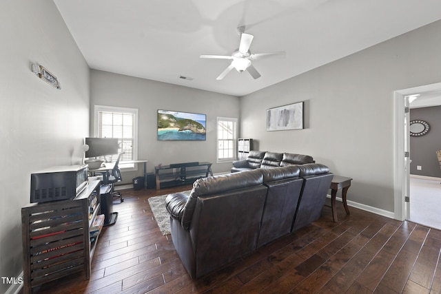 living area with dark wood-type flooring, a healthy amount of sunlight, baseboards, and a ceiling fan