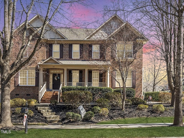 view of front facade with covered porch and brick siding