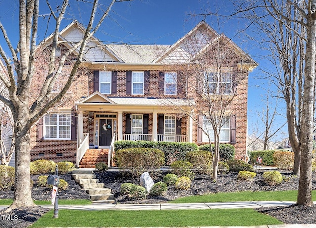 view of front facade featuring brick siding and covered porch