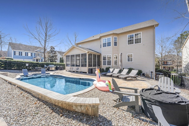 view of swimming pool with a fenced backyard, a sunroom, and a patio