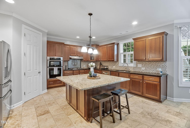 109 Skywater Ln, Holly Springs, NC 27540 - kitchen featuring appliances with stainless steel finishes, tasteful backsplash, brown cabinetry, light stone counters, and recessed lighting