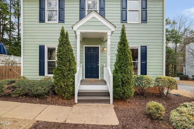 view of exterior entry featuring fence