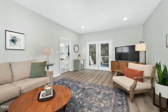 living area with baseboards, wood finished floors, and recessed lighting