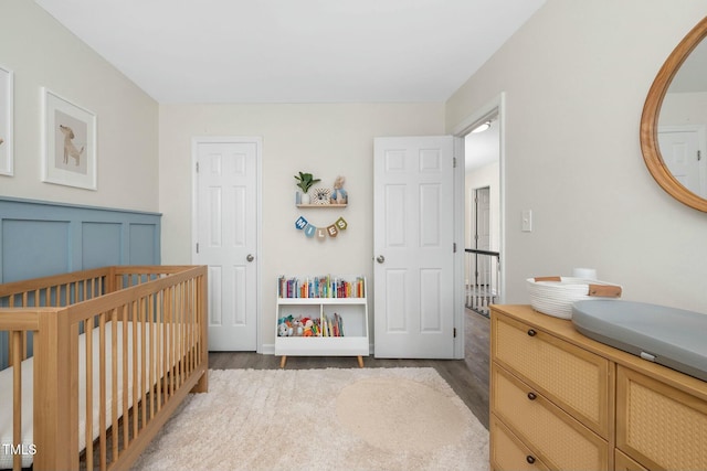 bedroom featuring a crib and wood finished floors