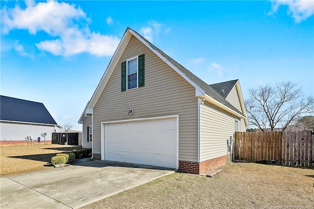 view of home's exterior featuring concrete driveway, a yard, and fence