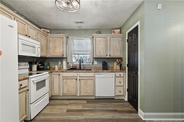 kitchen featuring light brown cabinets, white appliances, dark wood-type flooring, a sink, and visible vents