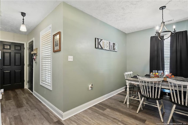 dining area featuring dark wood-style flooring, a textured ceiling, and baseboards