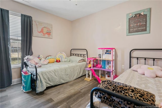 bedroom with baseboards and wood finished floors