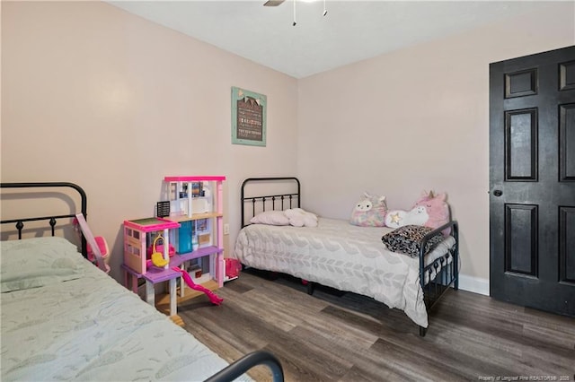 bedroom featuring baseboards, a ceiling fan, and dark wood-style flooring