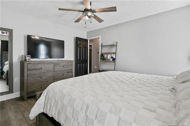 bedroom with a ceiling fan, a textured ceiling, and wood finished floors