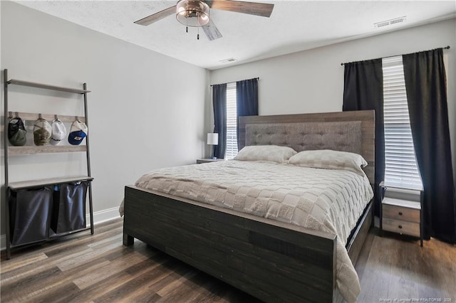 bedroom featuring visible vents, ceiling fan, baseboards, and wood finished floors