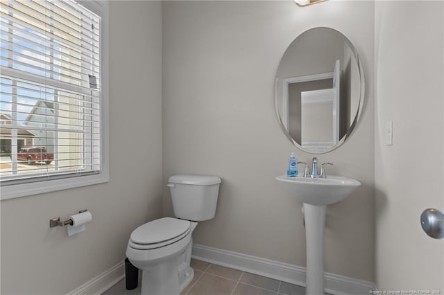 bathroom featuring a sink, tile patterned flooring, toilet, and baseboards