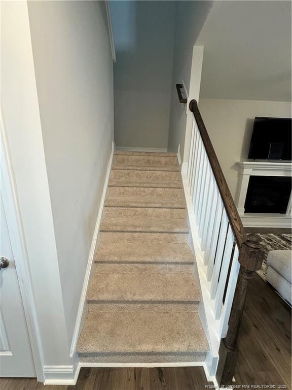 stairway with baseboards and wood finished floors