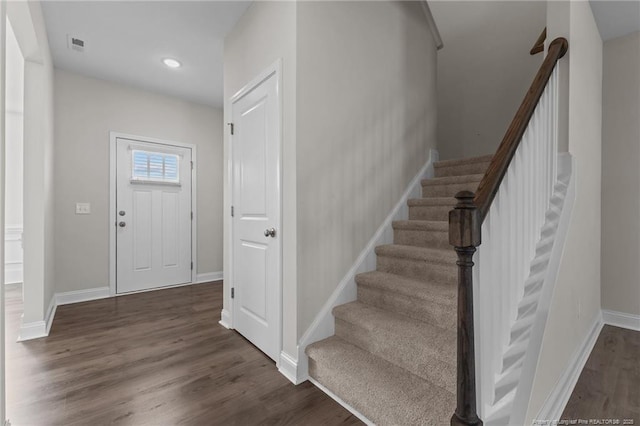 entrance foyer featuring visible vents, stairway, baseboards, and wood finished floors