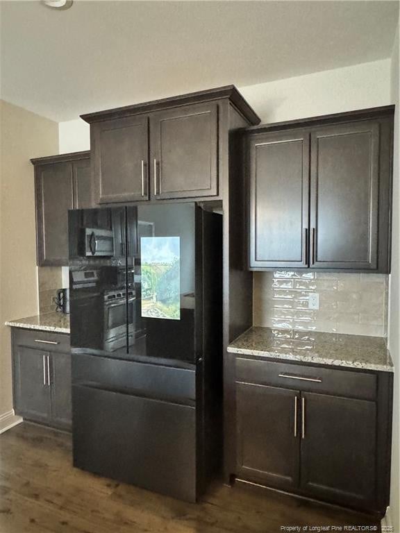 kitchen featuring light stone countertops, tasteful backsplash, dark wood finished floors, and dark brown cabinets