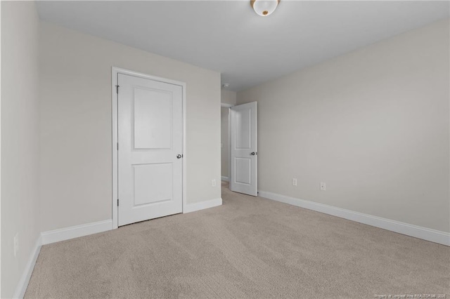 unfurnished bedroom with carpet floors and baseboards