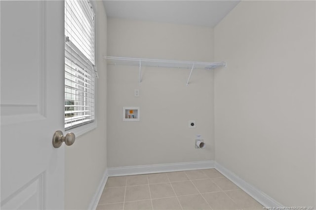 laundry area with laundry area, baseboards, washer hookup, electric dryer hookup, and light tile patterned flooring