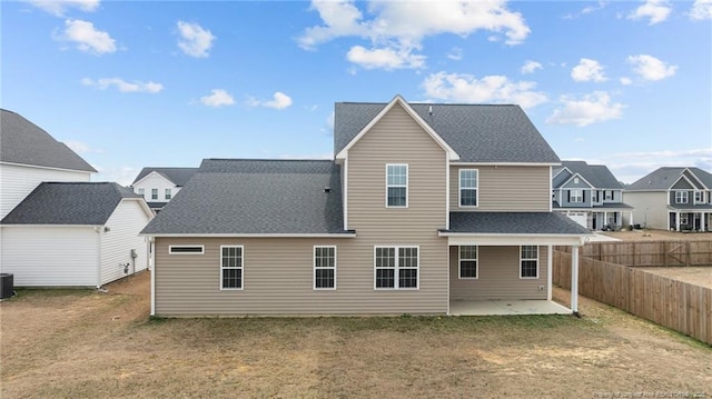 rear view of property with cooling unit, a shingled roof, a patio area, a residential view, and a fenced backyard