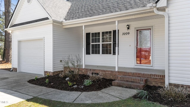 view of exterior entry featuring a porch and roof with shingles