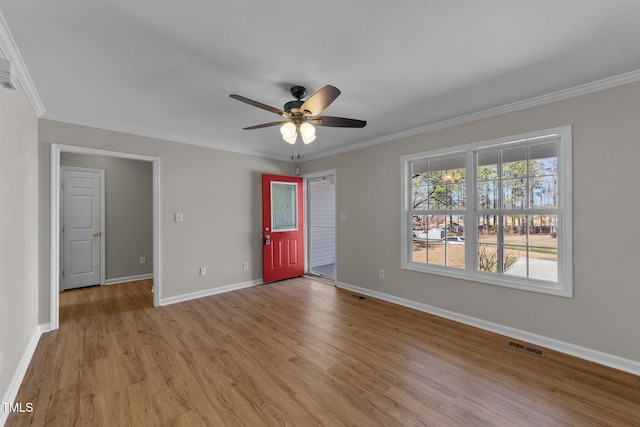 interior space featuring baseboards, visible vents, ceiling fan, crown molding, and light wood-type flooring