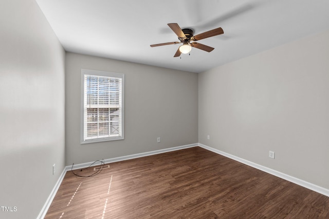 spare room with dark wood-style floors, baseboards, and a ceiling fan