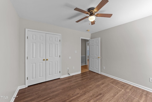 unfurnished bedroom with a closet, visible vents, baseboards, and wood finished floors