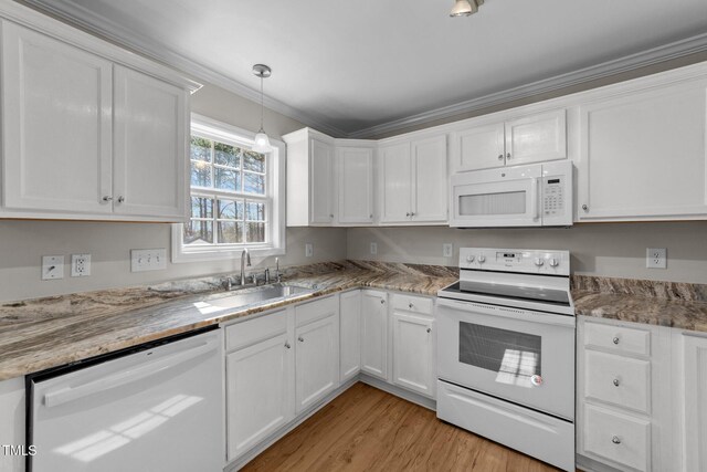 kitchen featuring hanging light fixtures, white cabinetry, a sink, light wood-type flooring, and white appliances