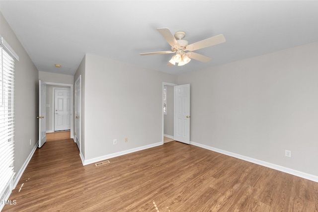 empty room with visible vents, ceiling fan, light wood-style flooring, and baseboards