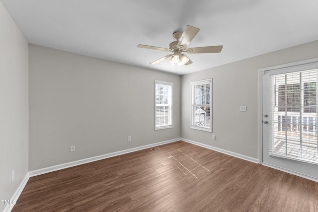 unfurnished room with a healthy amount of sunlight, ceiling fan, baseboards, and wood finished floors