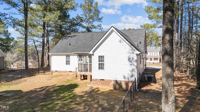 back of house featuring central AC, a shingled roof, fence, crawl space, and a lawn