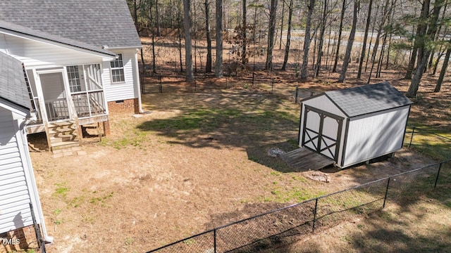 view of yard with fence private yard, a storage unit, a sunroom, and an outbuilding