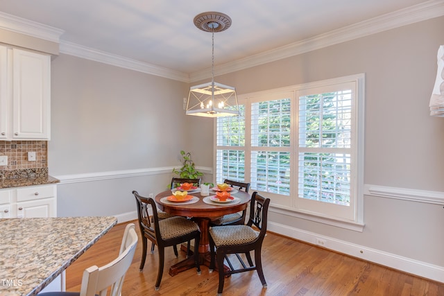 dining room with light wood-type flooring, baseboards, a chandelier, and ornamental molding