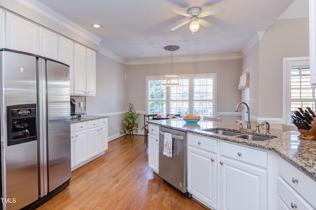 kitchen with a sink, appliances with stainless steel finishes, white cabinets, and a ceiling fan