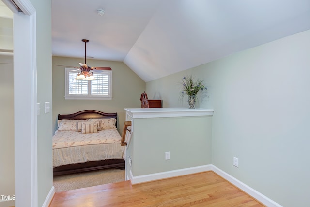 unfurnished bedroom featuring lofted ceiling, wood finished floors, and baseboards