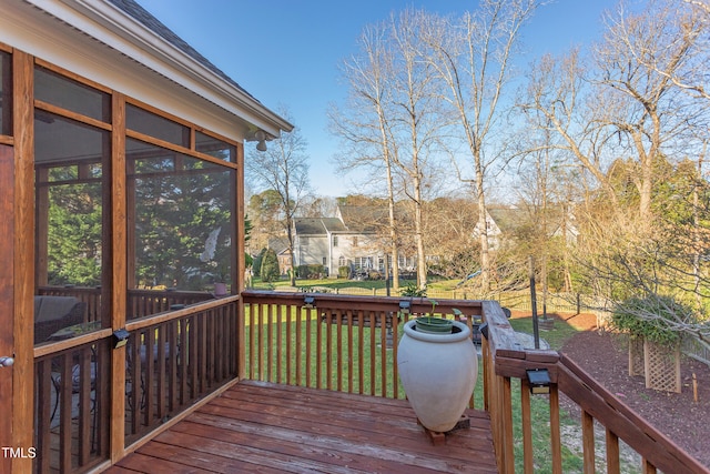 deck with a lawn and a sunroom