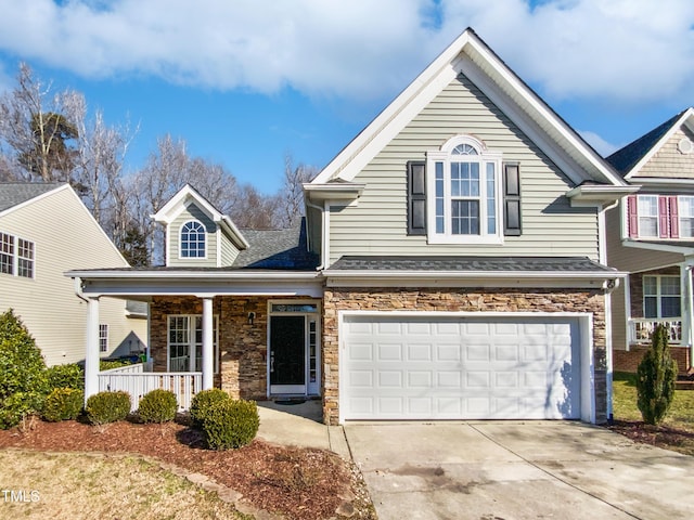 view of front of home featuring a garage, covered porch, driveway, and stone siding