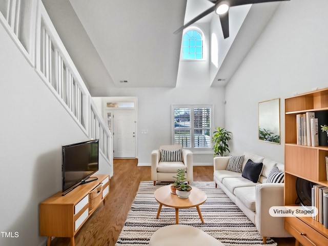 living area featuring visible vents, a healthy amount of sunlight, stairway, and wood finished floors