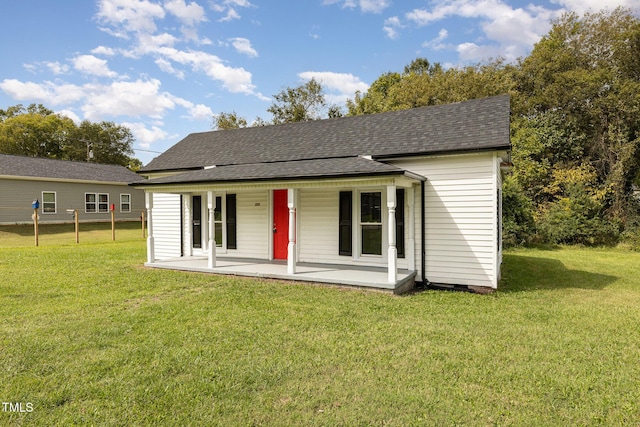 view of front of home with a porch, a front lawn, and roof with shingles