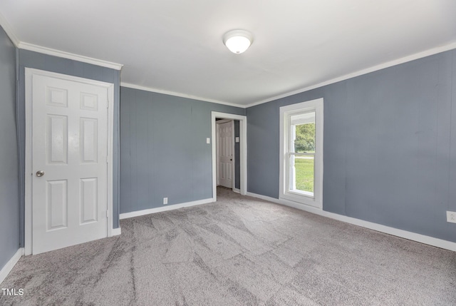 spare room featuring ornamental molding, carpet floors, and baseboards